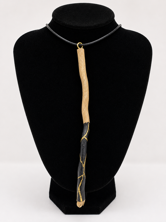 Long driftwood pendant necklace featuring black and gold kintsugi style design