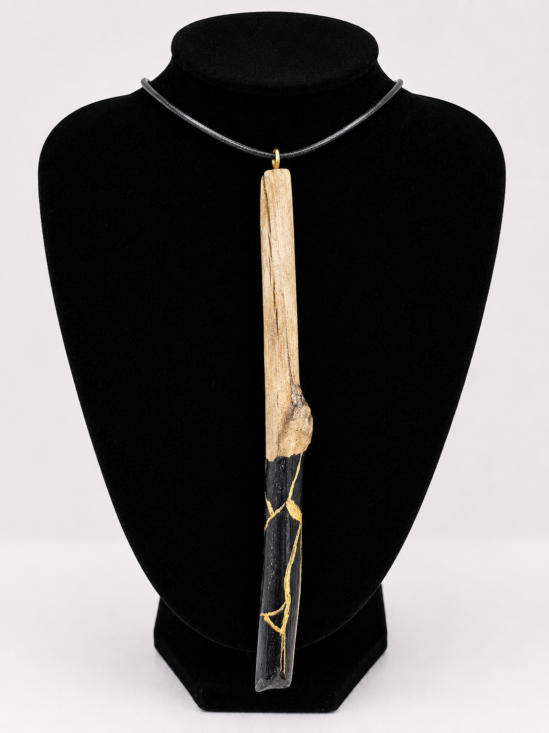 Long driftwood pendant necklace featuring black and gold kintsugi style design
