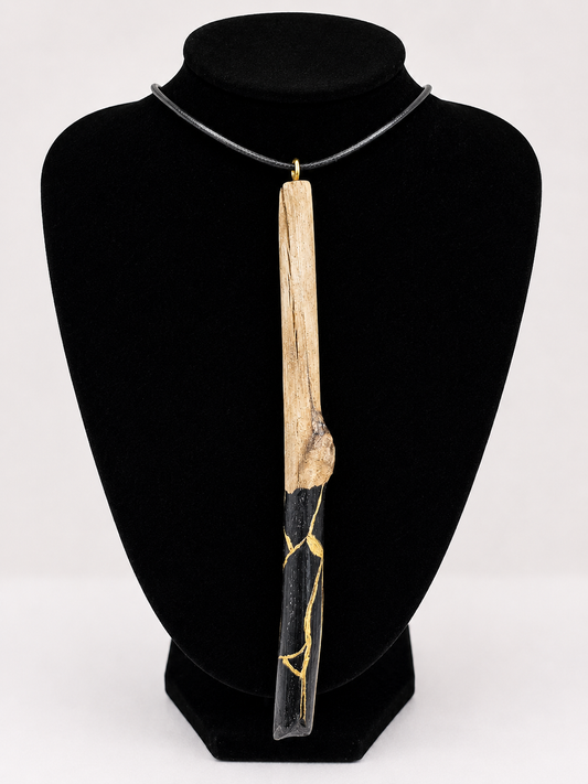 Long driftwood pendant necklace featuring black and gold kintsugi style design