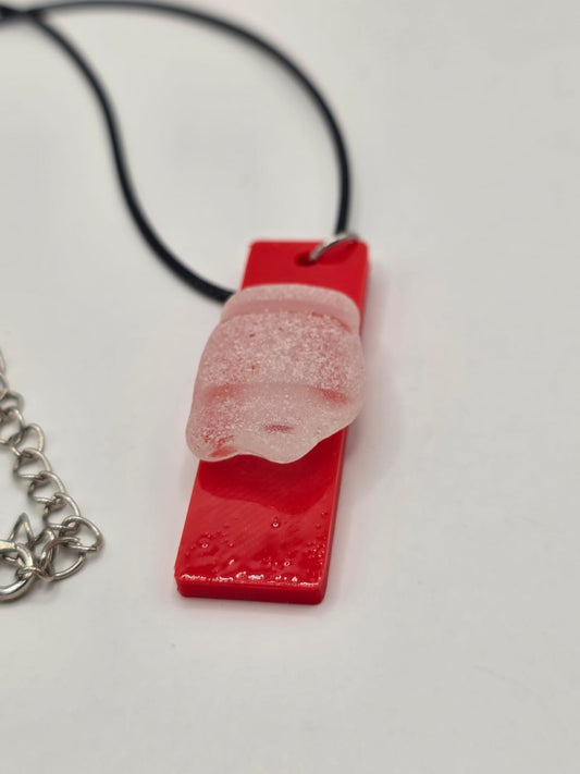 Sea glass pendant necklace on a red background with black waxed cord adjustable necklace