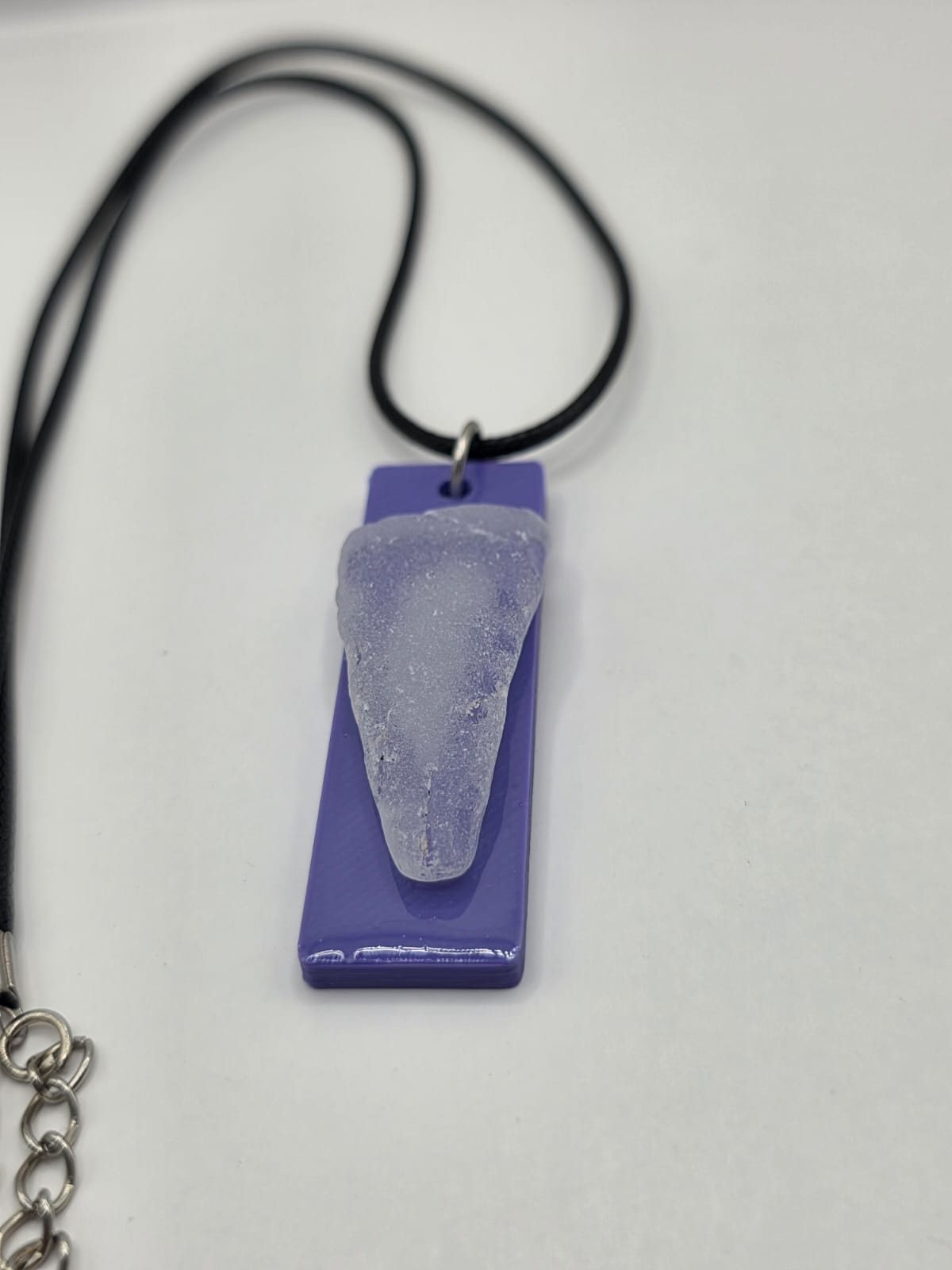 Sea glass pendant necklace on a purple background with black waxed cord adjustable necklace