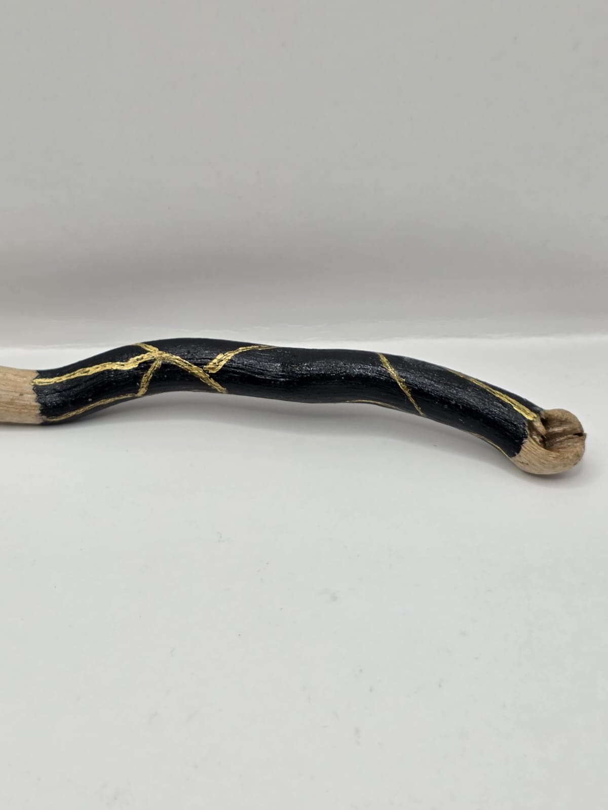 Long driftwood pendant necklace featuring black and gold kintsugi style design