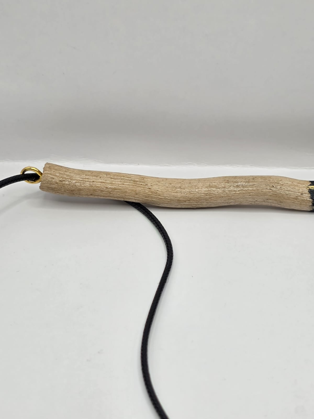 Long driftwood pendant necklace featuring black and gold kintsugi style design