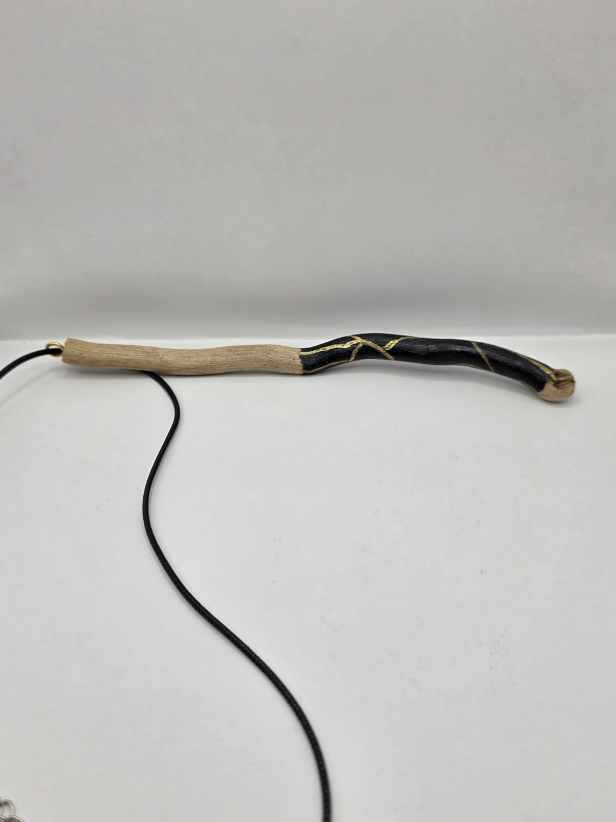 Long driftwood pendant necklace featuring black and gold kintsugi style design