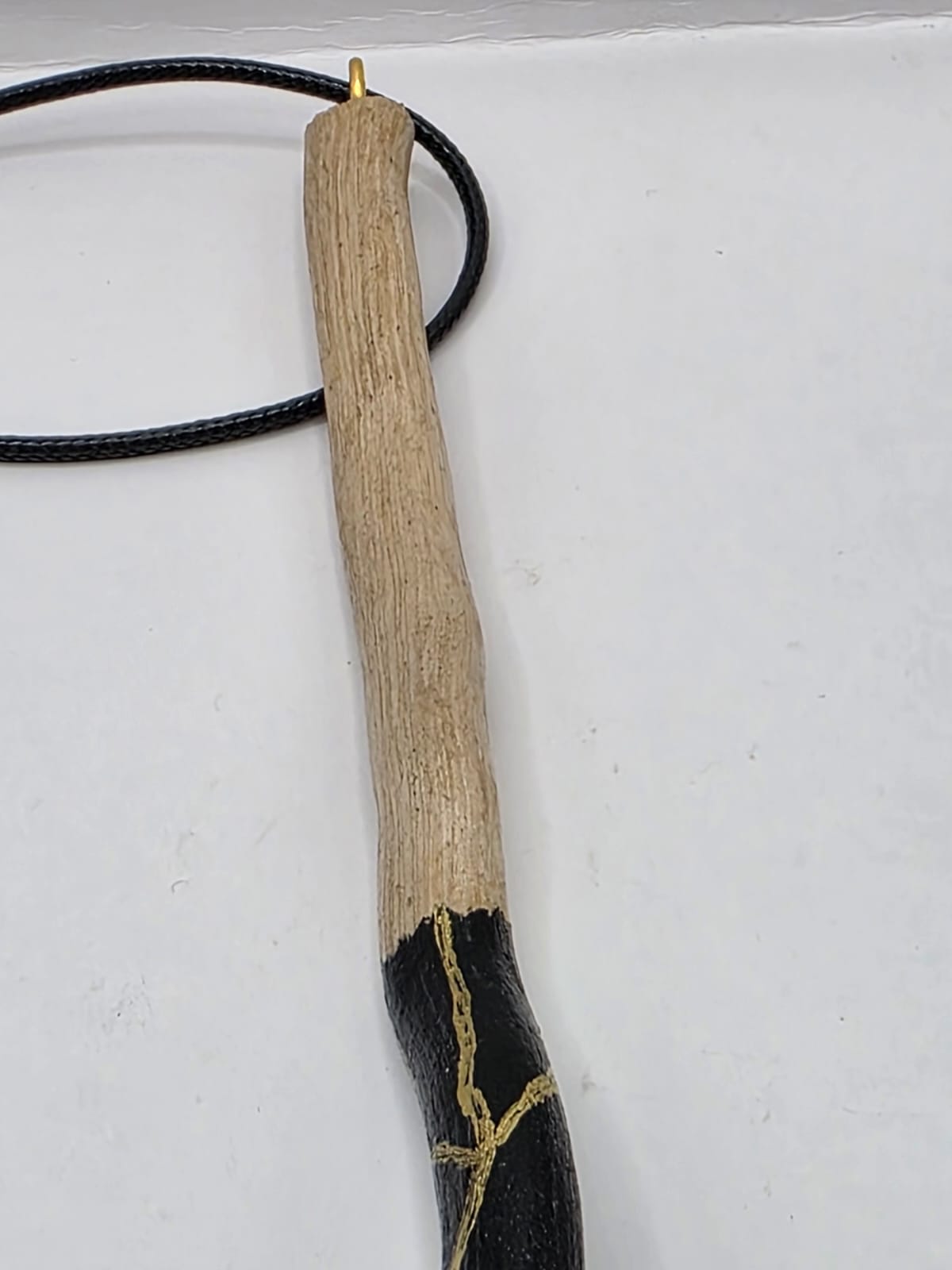 Long driftwood pendant necklace featuring black and gold kintsugi style design
