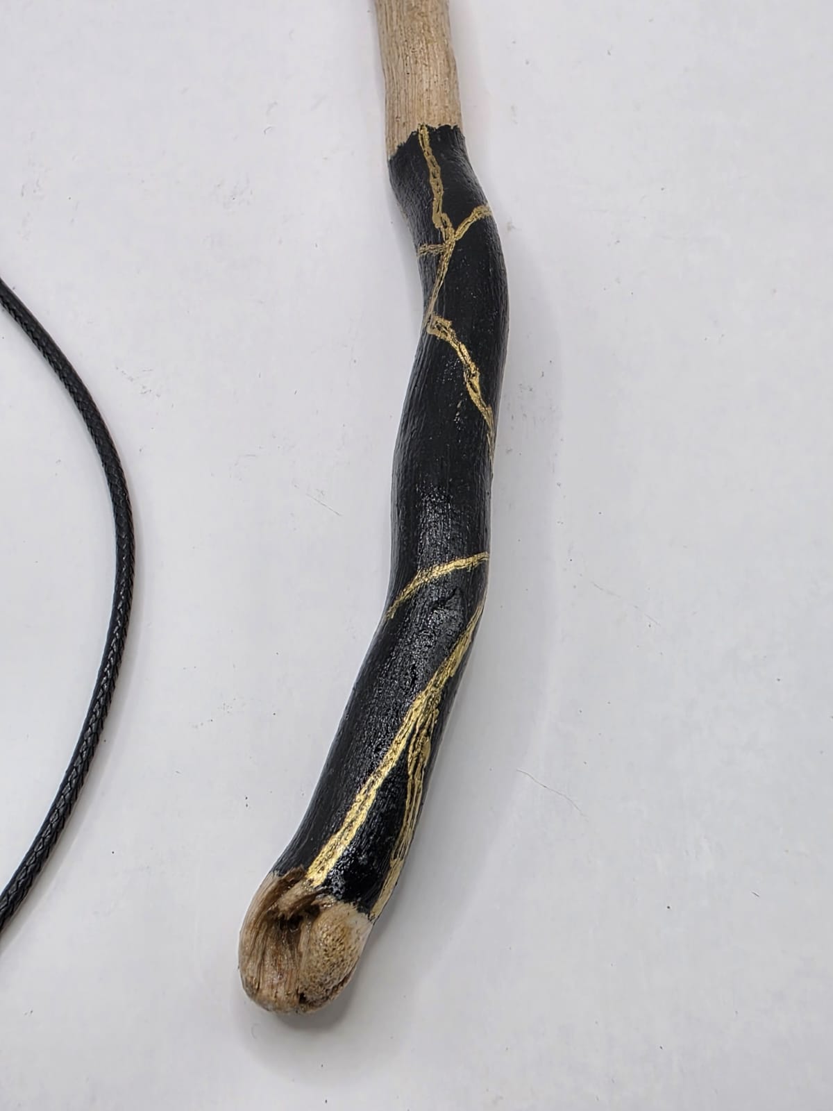 Long driftwood pendant necklace featuring black and gold kintsugi style design