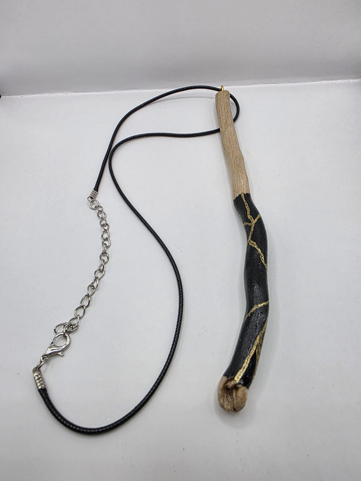 Long driftwood pendant necklace featuring black and gold kintsugi style design