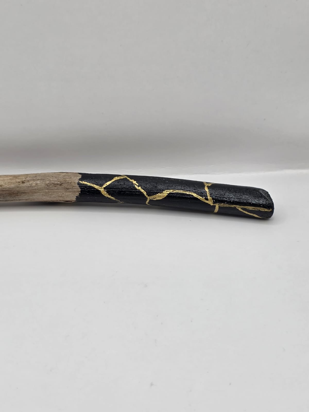 Long driftwood pendant necklace featuring black and gold kintsugi style design