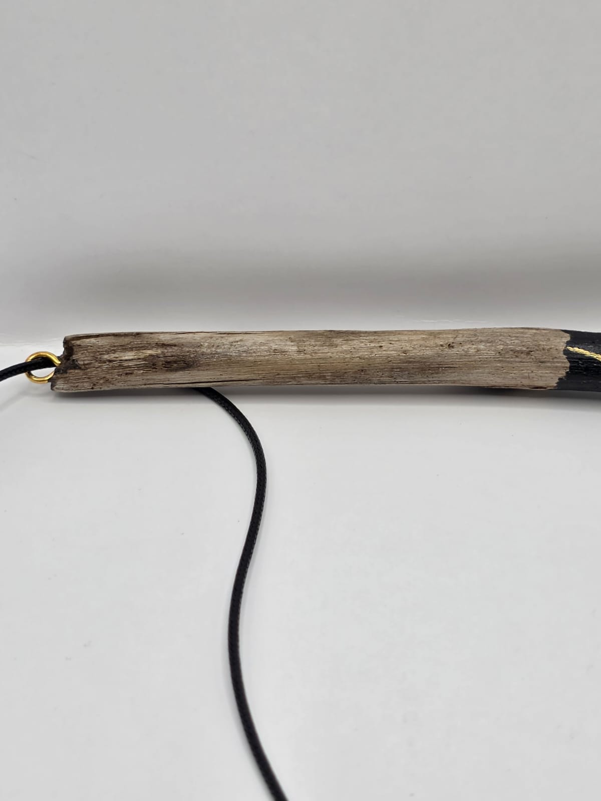 Long driftwood pendant necklace featuring black and gold kintsugi style design