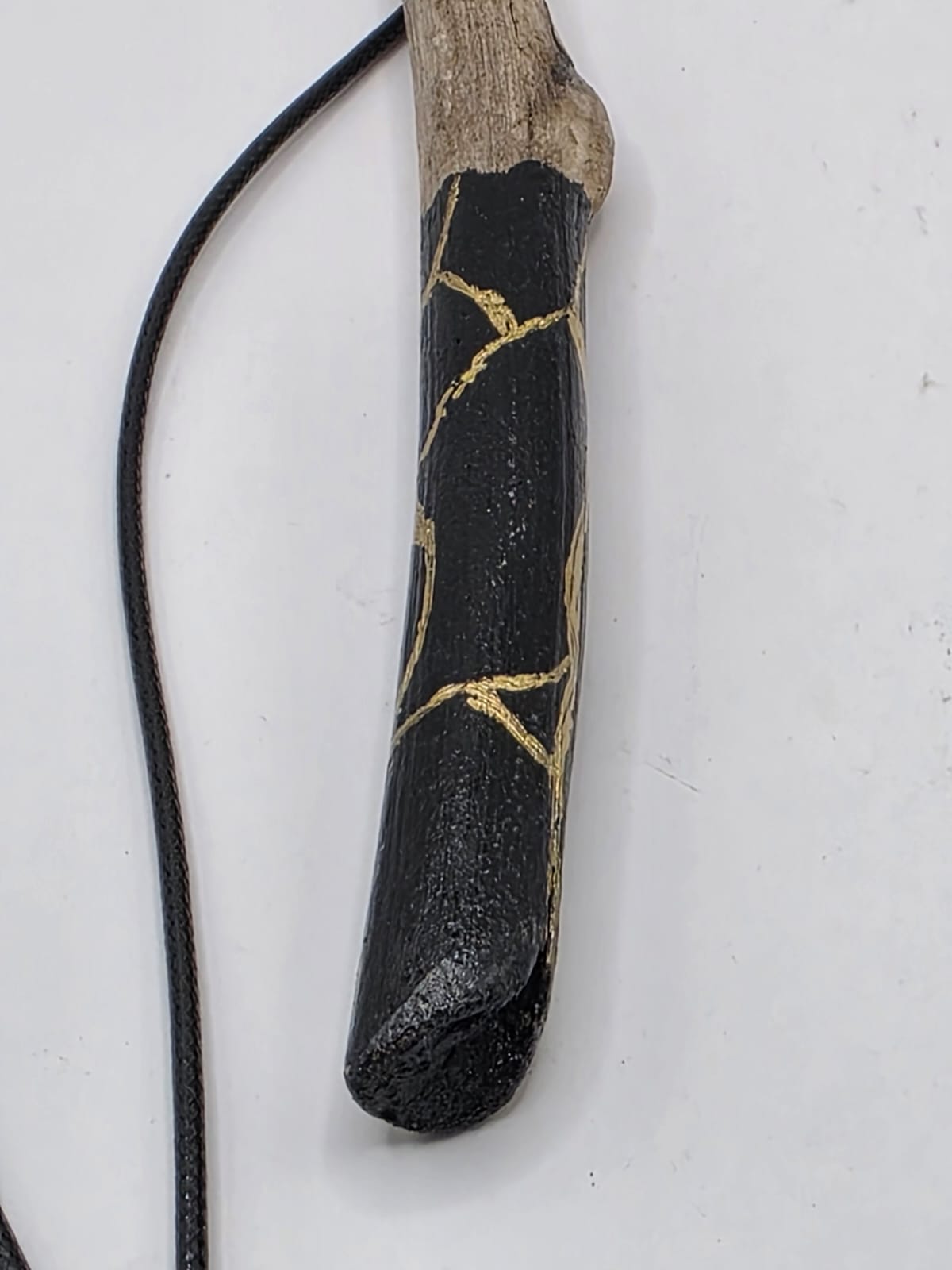 Long driftwood pendant necklace featuring black and gold kintsugi style design