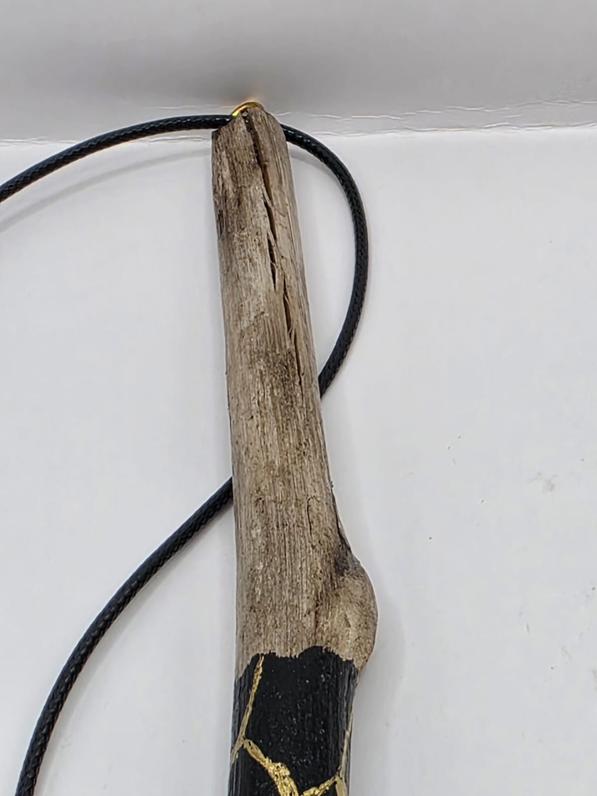 Long driftwood pendant necklace featuring black and gold kintsugi style design