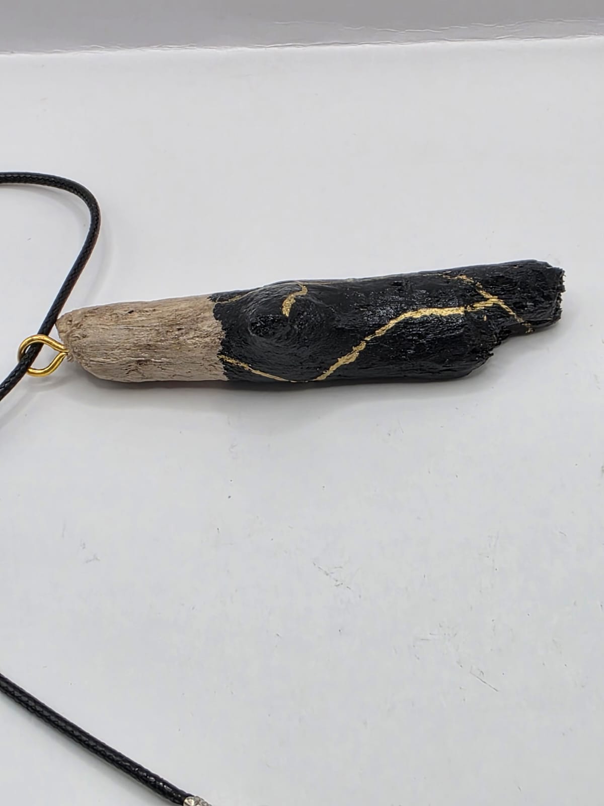 Driftwood pendant necklace featuring black and gold kintsugi style design