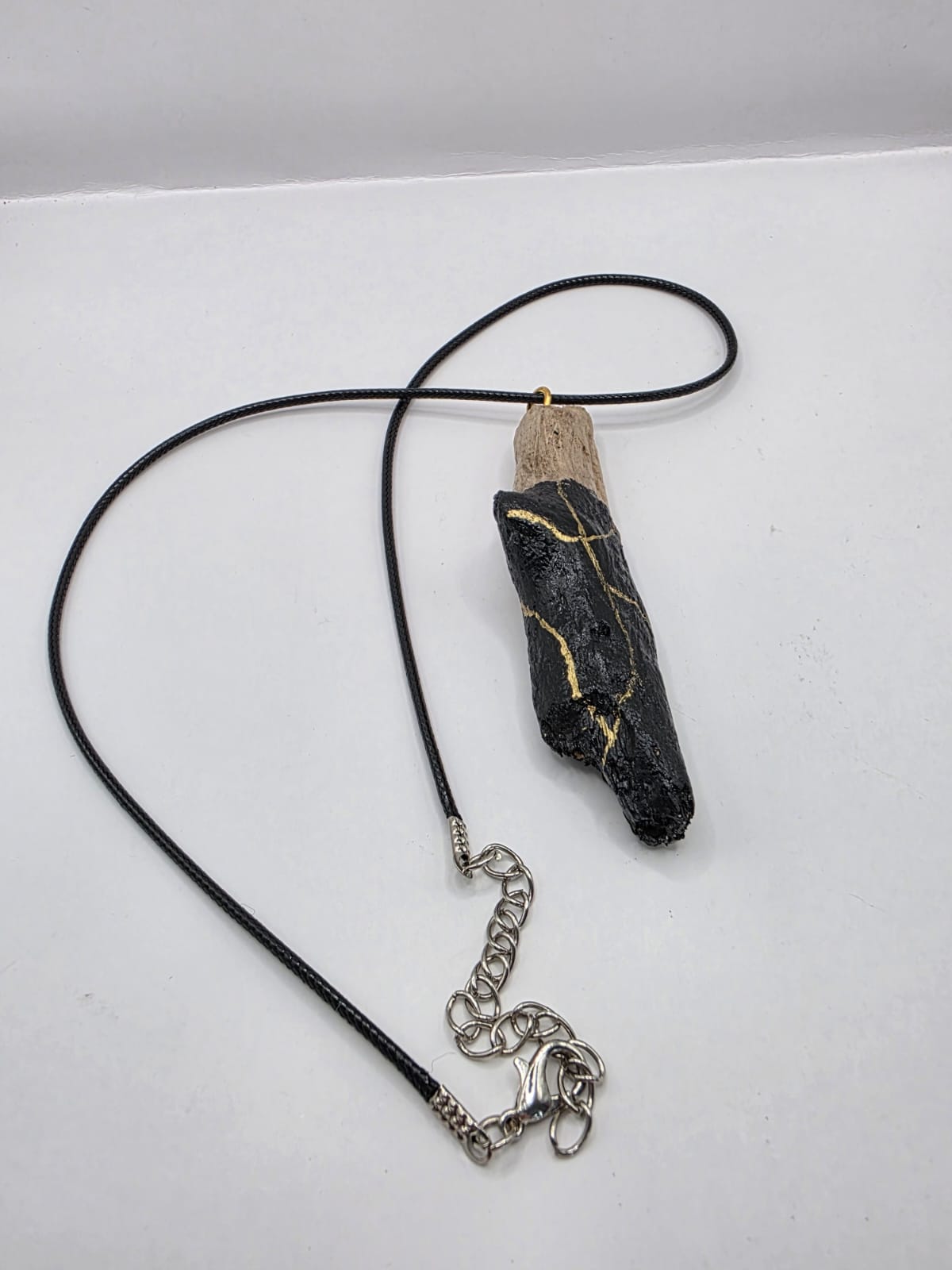 Driftwood pendant necklace featuring black and gold kintsugi style design
