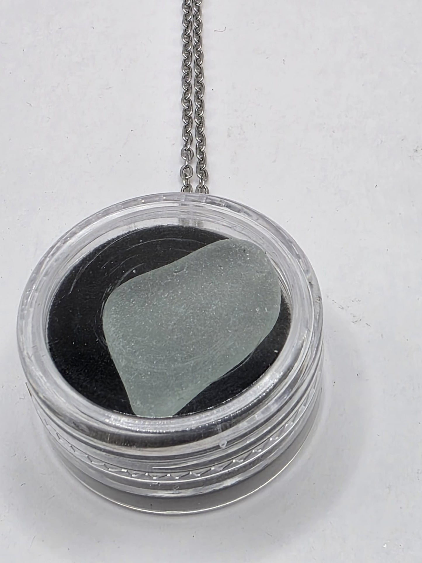 Sea Glass in a display case which can be opened as a pendant necklace on a stainless steel chain