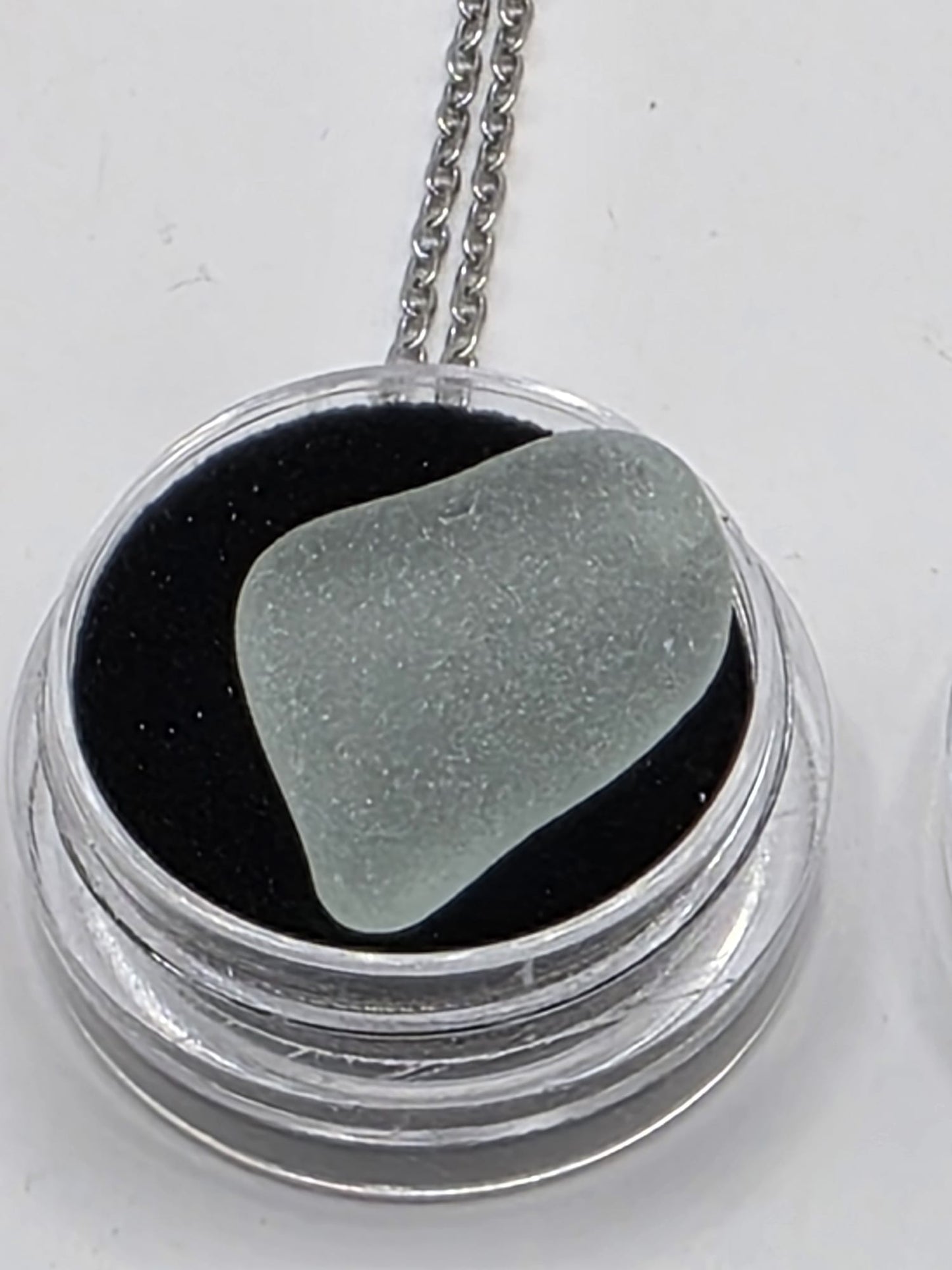 Sea Glass in a display case which can be opened as a pendant necklace on a stainless steel chain