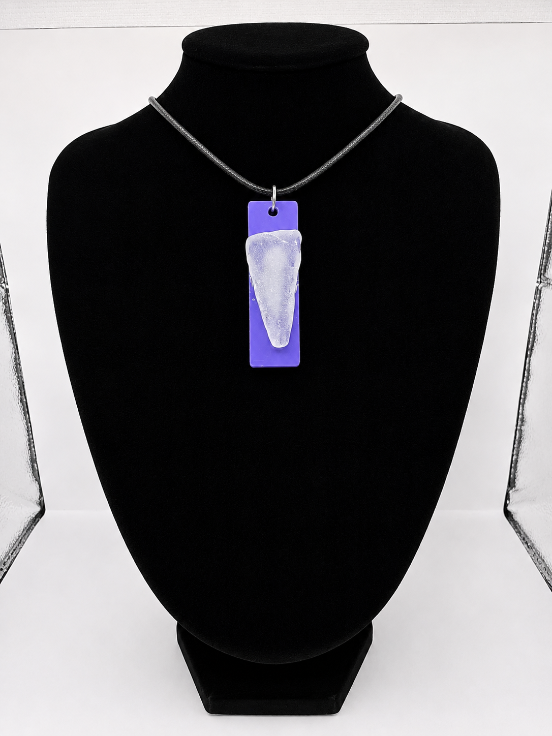 Sea glass pendant necklace on a purple background with black waxed cord adjustable necklace