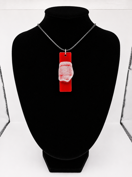 Sea glass pendant necklace on a red background with black waxed cord adjustable necklace