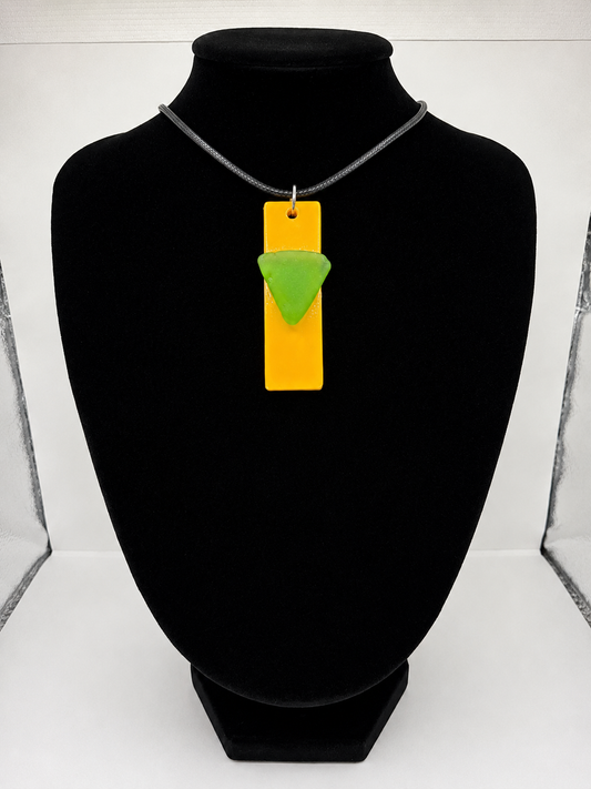 Sea glass pendant necklace on a yellow background with black waxed cord adjustable necklace